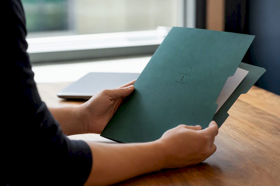 Hands holding encrypted file folder on desk