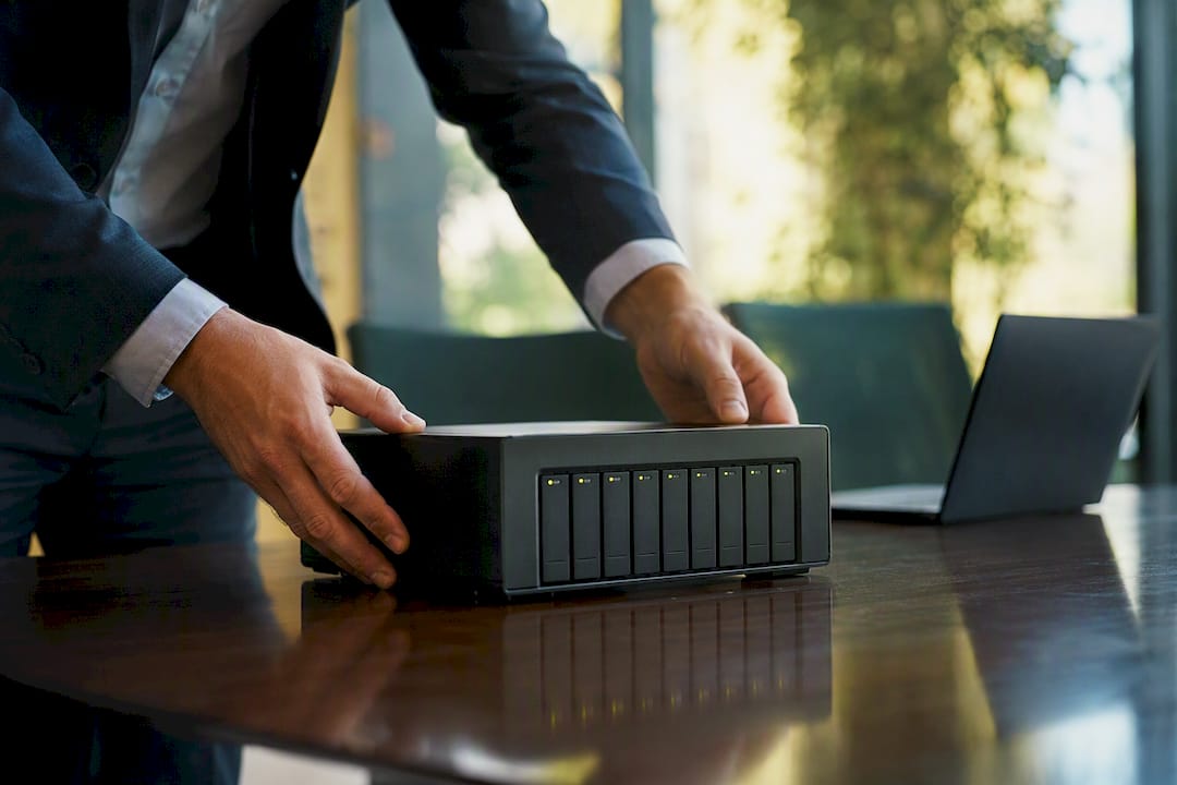 Hands managing license metering device on desk